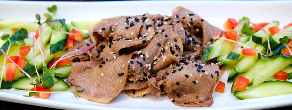 Salatalık ve dolmalık biberle hazırlanmış, dilimlenmiş sığır diliyle kaplanmış, susam tohumlu mikroçerez ve zeytinyağı ve soya sosuyla çeşnili, zarif ev yapımı..