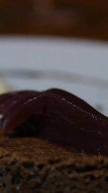 Sıcak çikolatalı tatlı konseptiyle serpiştirilmiş beyaz arka plandaki bir tabakta taze yapılmış çikolatalı kek. Yüksek kalite 4k görüntü