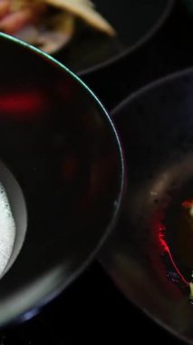 Siyah tabakta kuzu etli gurme yemek masası kremalı patates püresi, beyaz köpüklü havuç, pancar kökü ve hamur köftesi modern tarzda servis ediliyor..