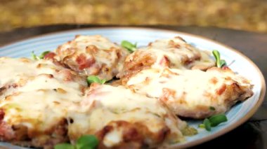 Fransız usulü lezzetli et aromalı et pirzolası. Kızarmış mantar, soğan, domates ve erimiş peynirle kaplı. Yukarıdan bakıldığında siyah taş levha tepsisinde. Yüksek kalite fotoğraf