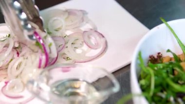 Mantarlı roka salatası, sebze, yağ, soğan turşusu, restoranda soya soslu beyaz tabak. Şef hazırlıyor. Sofraya ve pişirme sürecine marine edilmiş mantar servis ediliyor.. 