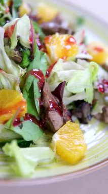 Krema soslu tavuk ciğeri, kızarmış patates, mantar ve beyaz porselen tabakta karışık yeşil salata elit bir restoranda kahverengi ahşap bir masada.. 