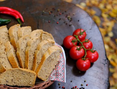 Ormandaki bir kütükte, barbekü sepetinde bir parça ekmek, etrafta vişneli domates, sonbaharda sarı yapraklar. Yüksek kalite fotoğraf