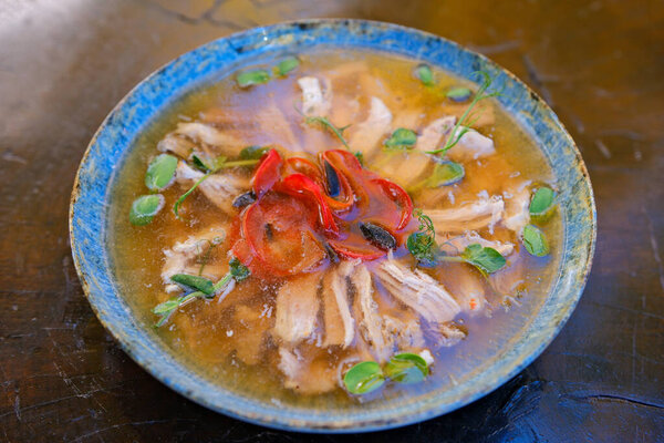 Chicken aspic, a traditional cold savory appetizer, served in portion form on a plate placed on a wooden table. Polish cuisine and Eastern European culinary tradition. Top view. Close-up. High quality