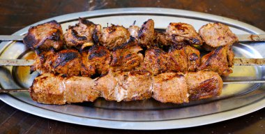 Shashlik ya da şiş kebap ızgarada ızgara mangal kömürü ve ızgara sebze. Metal şiş üzerinde ızgara domuz eti. Yüksek kalite fotoğraf