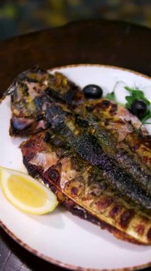 Lezzetli ızgarada limon ve mangalda taze biberiye ile ızgara edilmiş balık. Sağlıklı, gurme bir yemek için mükemmel. Yüksek kalite 4k görüntü