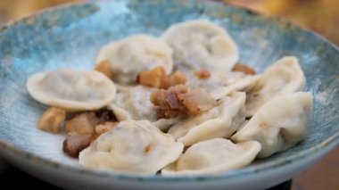 Sonbahar yapraklarının arka planında bir tabakta kıvrılmış hamur köfteleri. Yüksek kalite 4k görüntü