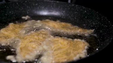 Aşırı yakın çekim ve yavaş çekimde kızgın yağ köpürmesi ya da dökme demir tavada köpürmesi ya da tavada kızarırken kızgın balık ateş kuyusu ya da kamp ateşi üzerinde kırıntılarla dövüldü. Yüksek kalite 4k 