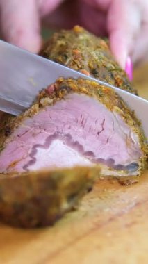 Şef taze ızgara et dilimliyor. Mutfaktaki ahşap kesme tahtasının üzerinde bıçakla. Yemekler yakınlaştırılıyor. Pişmiş et dilimleme