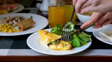 Tatlı biberli ve domatesli parlak sarı omlet çatal ve bıçakla kesilir. Salata yaprakları, çorba ve diğer Vietnam yemekleriyle servis edilen lezzetli bir öğle yemeği..