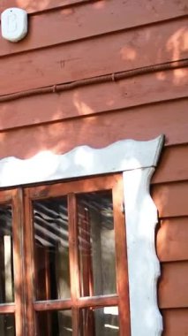 Küçük ahşap evde rahat bir teras. Yazın ormanda küçük bir kır evinde teras. Masa ve kahverengi kanepe, tahta duvardaki ağaçların gölgeleri, yavaş çekim. Yüksek kalite 4k görüntü