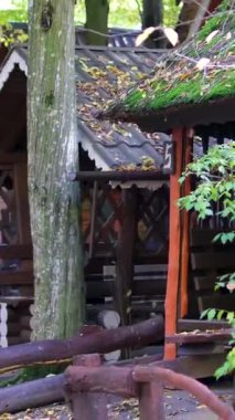 Modern bir kulübe, siyah kıvrımlı metal bir duvar ve orman inzivasında ahşap bir balkon. Yüksek kalite 4k görüntü