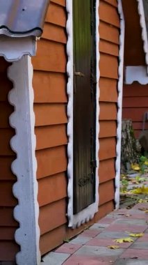 Koyu turuncu, kahverengi ahşap çitlerle kaplı. Samimi evler ve orman ağaçlarının yanında sivri uçlu beyaz çitler kırsal kesimlerde doğal dokular ve huzurlu kırsal çevrede sıcak güneş ışığı yaratıyor..