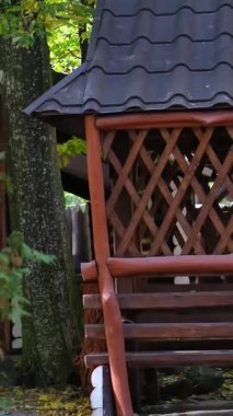 Parktaki boş ahşap salıncağın yakın plan görüntüsü, yavaşça sallanan, yalnız ahşap salıncak konsepti, 4K. Yüksek kalite 4k görüntü