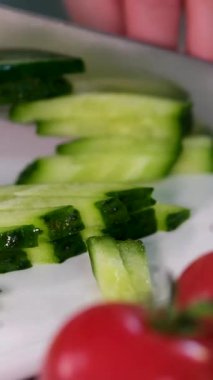 yeşil salatalıklar mutfakta bıçakla kesilir. Sağlıklı sebze salatası konsepti. Mutfaktaki yeşil salatalıklar yakın plan yaşam tarzını dilimlere ayırıyor. Yüksek kalite 4k görüntü