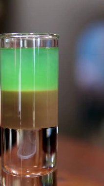 Barmen barda renkli katmanlı içkiler hazırlıyor. Yüksek kalite 4k görüntü