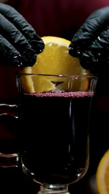 Sıcak şarap hazırlamak için portakal ekleyin. Kırmızı şarap, portakal dilimli tencere, portakal dilimleri kesme tahtasında. sıcak şarap test barmeni sıcak şarap hazırlar. Yakın plan. 