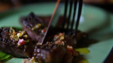  Bir restoranda sıcak bifteği tabakta kesmek için bıçak kullan. Yüksek kalite 4k görüntü