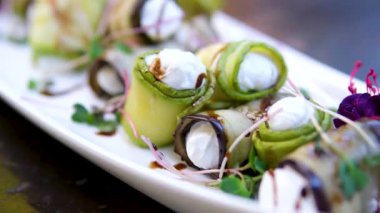 Patlıcan ruloları keçi peyniri ile doldurulmuş yeşil maydanoz ve çiçeklerle süslenmiş. Üst Manzara. Yüksek kalite fotoğraf