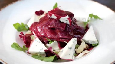 Rokfor peynirli salatanın üstüne vişne sosu ve beyaz tabağa dil dök. Yüksek kalite 4k görüntü