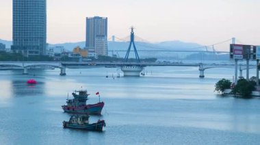 Da Nang Vietnam 'daki Han Nehri Köprüsü' nde gösterişli bir kablo dizayn ve şehir ışıkları altında gemi trafiği ve su üzerindeki yansımalar için merkezi yelken gibi bir açıklık var..