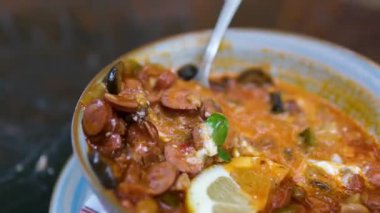 Gri tabakta solyanka çorbası, malzemeleri ortaya çıkarmak için el çırpması. Üst manzara, 4K. Yüksek kalite 4k görüntü