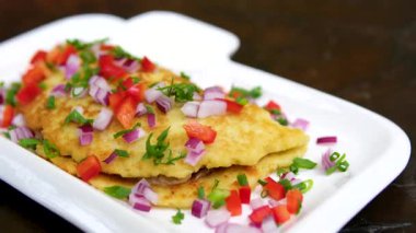 Omletli kahvaltı tabağı, dilimlenmiş tavuk, kiraz domatesleri, yeşil sos ve biberli jalapeno. Kırmızı biberli ve yeşil soğanlı büyük bir patates gözlemesi..