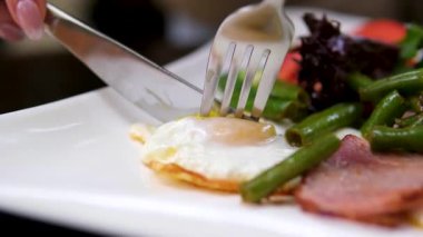 Yumurtaya, sosise, tosta ve fasulyeye domuz pastırması koymak için yakın plan. Yüksek kalite 4k görüntü