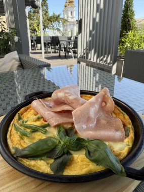 Yumurta karışımı sıcak bir tavada yüksek ısıda cızırdıyor, pirinç, jambon ve dilimlenmiş yeşil soğanlı yumuşak bir Asya omleti hazırlıyor, brunch, kahvaltı, öğle yemeği,.