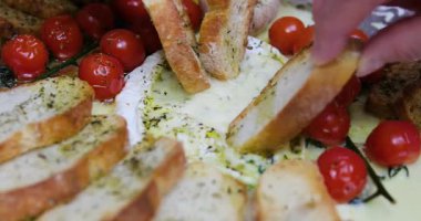 Camembert domatesli ve biberiyeli ev yemeği sahnesi fırın tepsisine dikkatlice yerleştirilmiş fırın için hazır konforlu mutfak anı ev yapımı peynirli yemek konseptini yakalıyor..