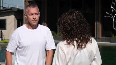 Genç kadın ve erkek, çok katlı binaların yatakhane alanına karşı ellerini kavuşturup birbirlerine sırt sırta dururlar. Erkek ve kız günlük çamaşır giyiyorlar. Ciddi konsantre ruh hali..