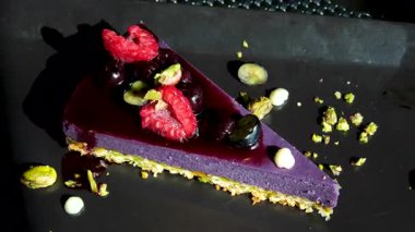 Lavanta, yaban mersini ve ahududu dönüşümlü ağır çekim video klipsiyle süslenmiş kremalı bir parça mor kadife pasta.,