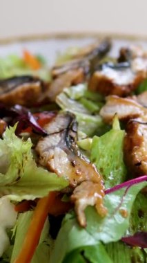 Yılan balığı salatası koyu soya soslu teriyaki unagi soslu salata, yılan balığı, chuka ve avokado bir kafede bir masada oturuyor. Asya mutfağı konsepti. Yüksek kalite 4k görüntü