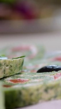 İnce, renkli krepler. Kırmızı, sarı ve yeşil kesikli krep krem peynirli ve somonlu gözlemelerin yakın çekim görüntüsü..