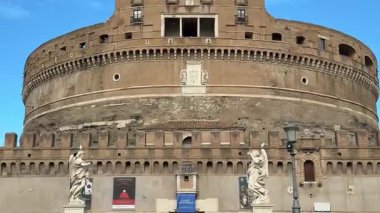 Roma 'daki Ponte Sant Angelo' nun sakin sinematik görüntüsü etkileyici melek heykelleri sergiliyor ve Vatikan 'a doğru tarihi bir yürüyüş yolu sunan Castel Sant Angelo' nun sürekli varlığı.