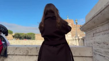 Bir grup insan, Ponte Sant Angelo turistleri Castel Sant Angelo 'ya dayanan etkileyici melek heykelleri sergiliyorlar ve Vatikan şehrine doğru tarihi bir yürüyüş yolu sunuyorlar. İtalya Roma 11.27.2025