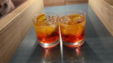 Gözlüklü Aperol kokteyli. Kokteyl aperol spreyi. Taze portakal dilimleri, buz, yeşiller ve iki siyah pipet. Tipik İtalyan içeceği, Prosecco köpüklü aperatif..