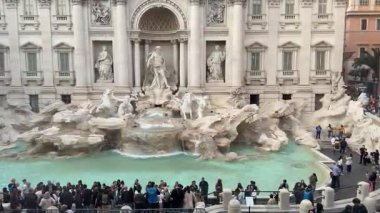 Roma 'daki Trevi Çeşmesi yakınlarında kalabalık içinde duran turistler, sembolik İtalyan anıtının fotoğraflarını çekmek için kuyrukta bekliyorlar. Bu durum, canlı atmosfer otantik seyahat deneyimini yansıtıyor. İtalya Roma' da 11.28.2025