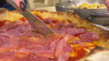 Domatesli makarna ve pizzacı kız pizzayı restoranda kaldırıyor. İtalyan pizzası yiyen kadın. Taze peynirli pizzanın yakın çekimi. Peynir dilimlenmiş gibi geriliyor. Yüksek kalite 4k