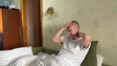 65 'lerin erkek masajcıları sabah kalktığında başını kaldıran adam şiddetli baş ağrısı ya da migren ağrısıyla kendine masaj yapmaya çalışırken uyanır. Yüksek kalite 4k 