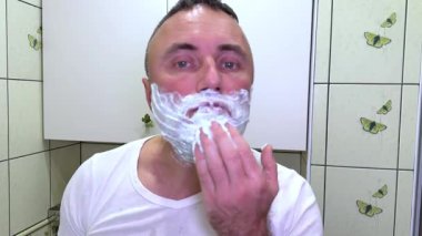 Kırk beş yaşında bir adamın uyanıp tıraş olurken, dişlerini fırçalarken, dambılları kaldırırken, mutfakta yemek yaparken ve başlarken gösterilen sabah klipleri. taze ve enerjik bir gün..