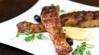 Izgaranın maşaları tavada kızaran sebzeleri ve balıkları karıştırıyor. Yüksek kalite 4k görüntü