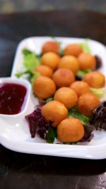 Çıtır peynirli toplar, kıtır kıtır, kıtır kıtır, kıtır kıtır, içinde erimiş peynir aperatifler, mezeler, parti tabakları ve konfor aşıkları için mükemmel. Yüksek kalite 4k görüntü