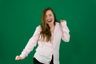 Güneş gözlüklü beyaz kızın stüdyoda iyi vakit geçirmesine sevindim. Mor arka planda dans eden muhteşem kıvırcık kadın portresi. Yüksek kalite fotoğraf