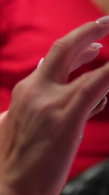 Kırmızı elbiseli cep telefonu elinde. Koyu arkaplanda kırmızı mavi ışıklı akıllı telefon. İşaretli yeşil renkli ekran. Telefonu kaldırır ve sabit tutar. 4k