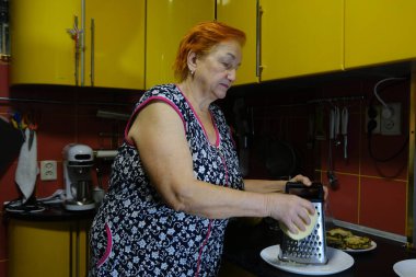 Ahşap masada peynir rendeleyen kadın, yakın plan. Yüksek kalite fotoğraf