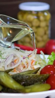 Şef bir restoranın mutfağında salata sosu döküyor. Domates turşusu 