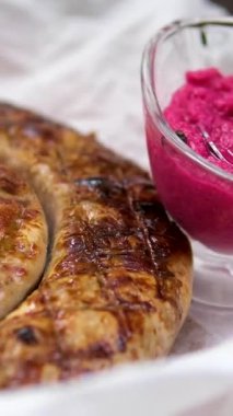 Koyu barbekü atmosferinde ızgarada cayır cayır yanan pancar suyu sosisli yaban turpu. Yüksek kalite 4k görüntü