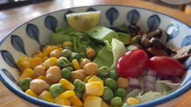 Fasulyeli salata, nohut, mısır ve domates, üstüne de siyah susam sosu. Yüksek kalite 4k görüntü