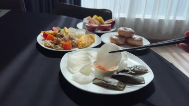 Tayland krakeri, kızarmış ince dilimler pirinç unu aromalı karides, çıtır pirinç keki. Sosa batırılmış pirinç cipsi.